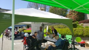 posAbilities team members and persons served hangout under a canopy tent at the Festival of Loss and Healing