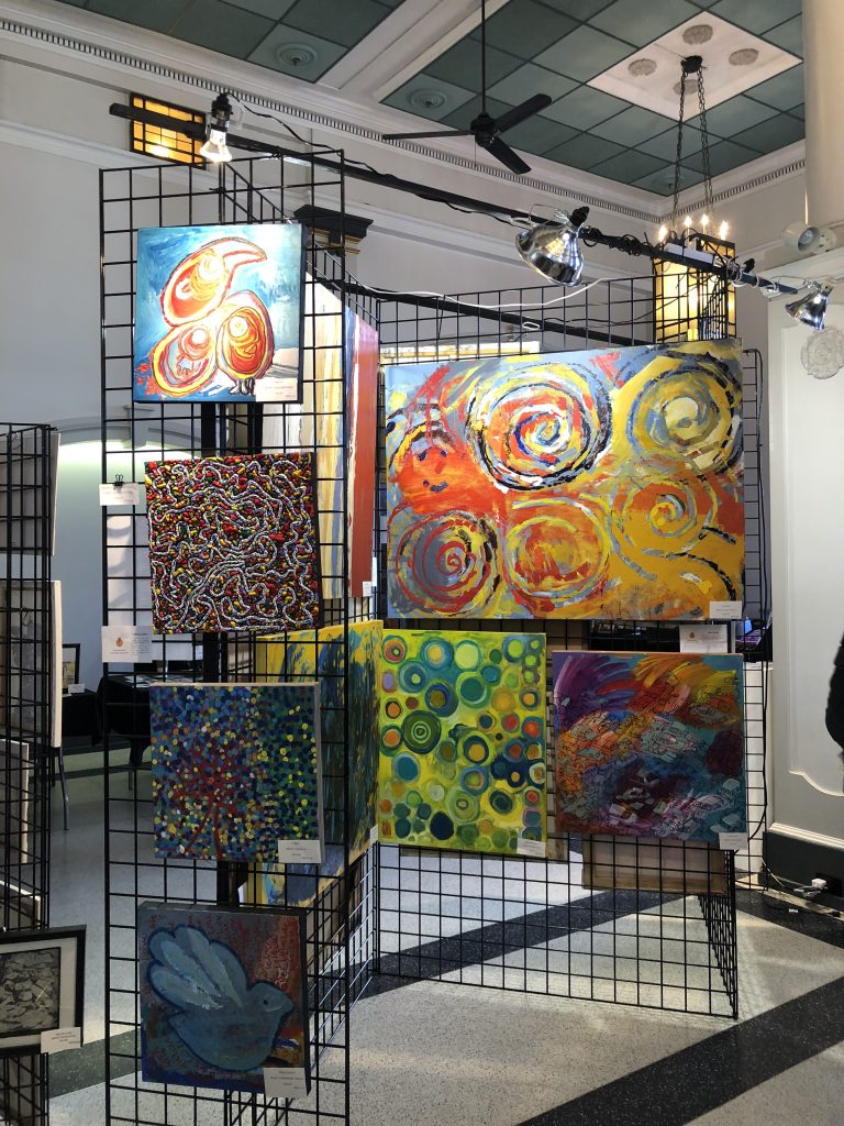 Colourful abstract paintings displayed on black lattices