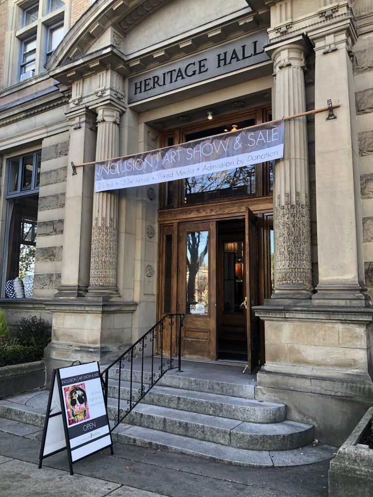 The open front door of Heritage Hall with a banner above announcing the Inclusion Art Show and Sale