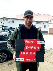 A man holding a delivery from Parallel 49
