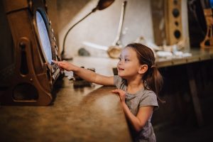 A young girl touches an interactive display at the museum