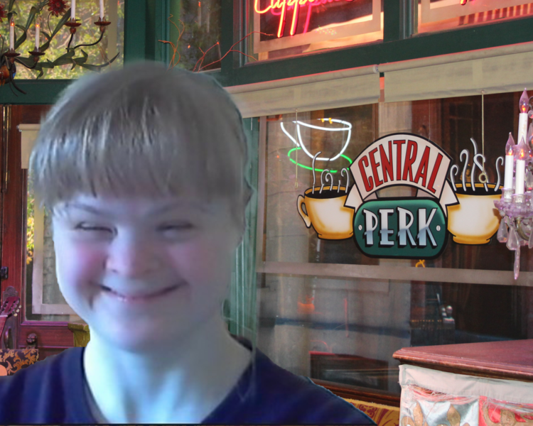 Blonde woman with Down Syndrome sits in front of a window that says "Central Perk"