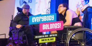 Two presenters in wheelchairs on stage at an Inclusion BC conference