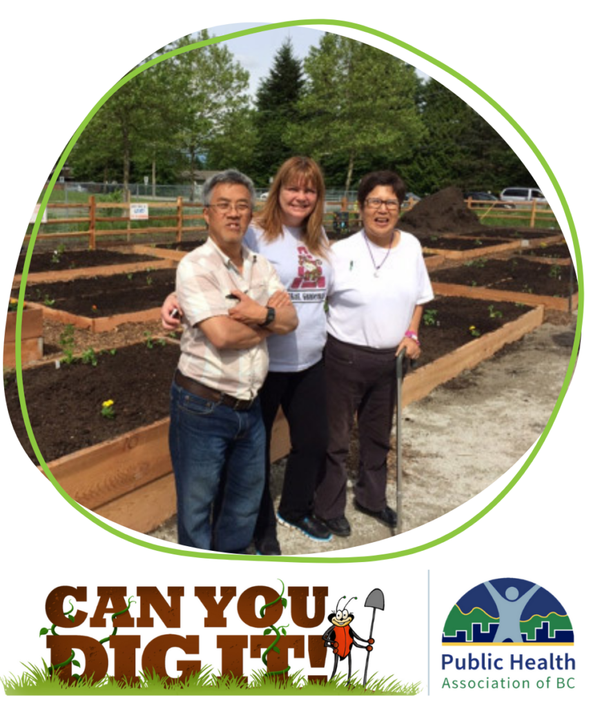 Three community members standing proudly in front of a new garden.